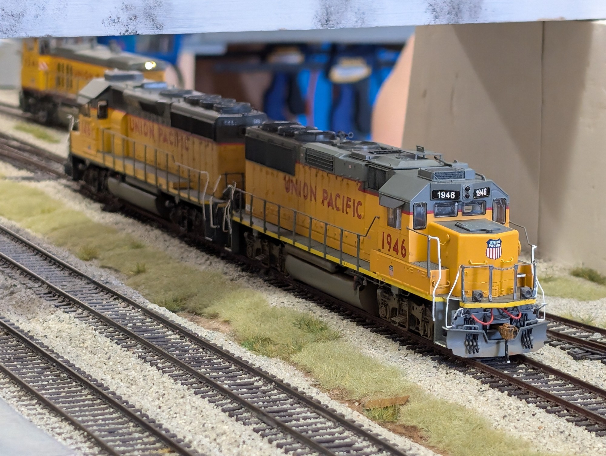 Yellow and grey diesels under a bridge