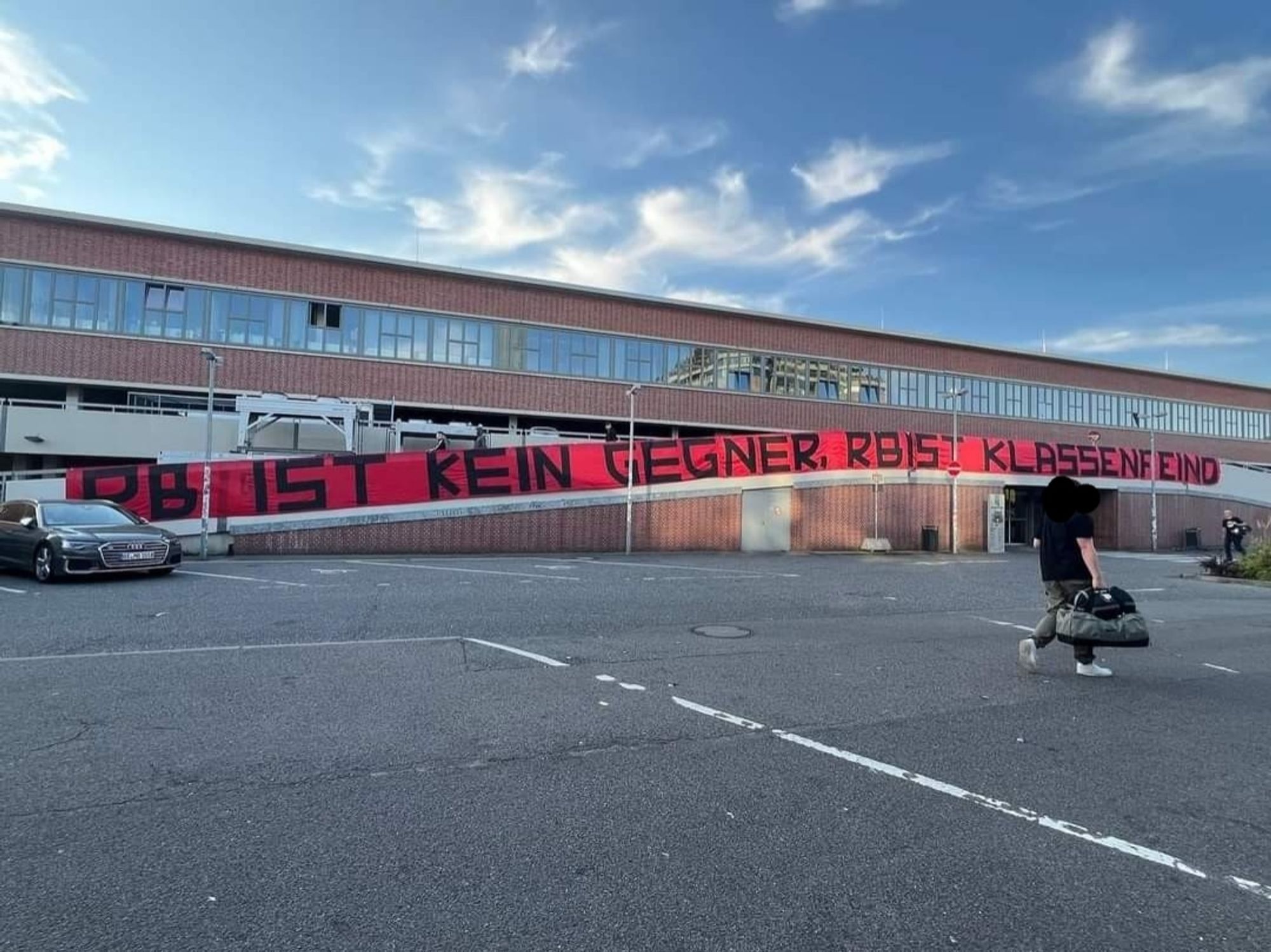 Banner an einem Parkhaus neben dem Gästezugang des Millerntorstadions, große schwarze Lettern (ca 2m hoch) auf rotem Banner (ca 30-40m lang):
RB IST KEIN GEGNER. RB IST KLASSENFEIND.