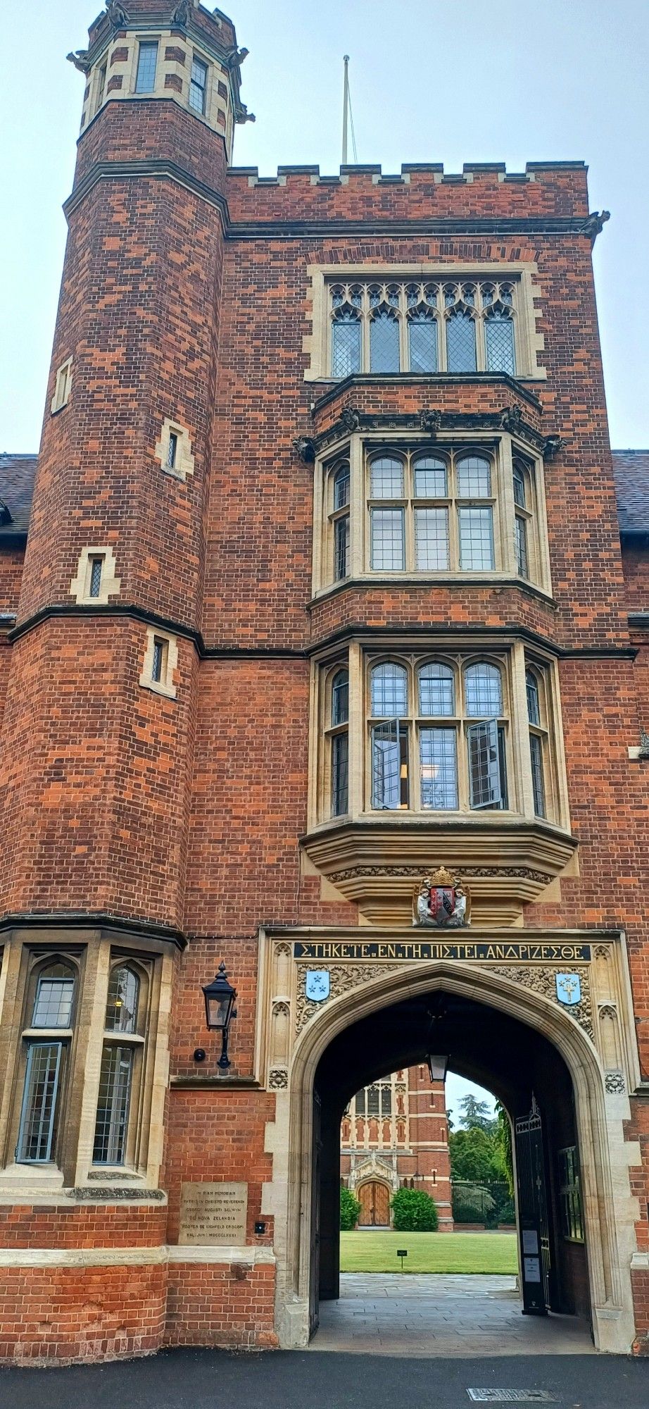 Image of red brick older building with sandstone archway – Selwyn College at Cambridge University.