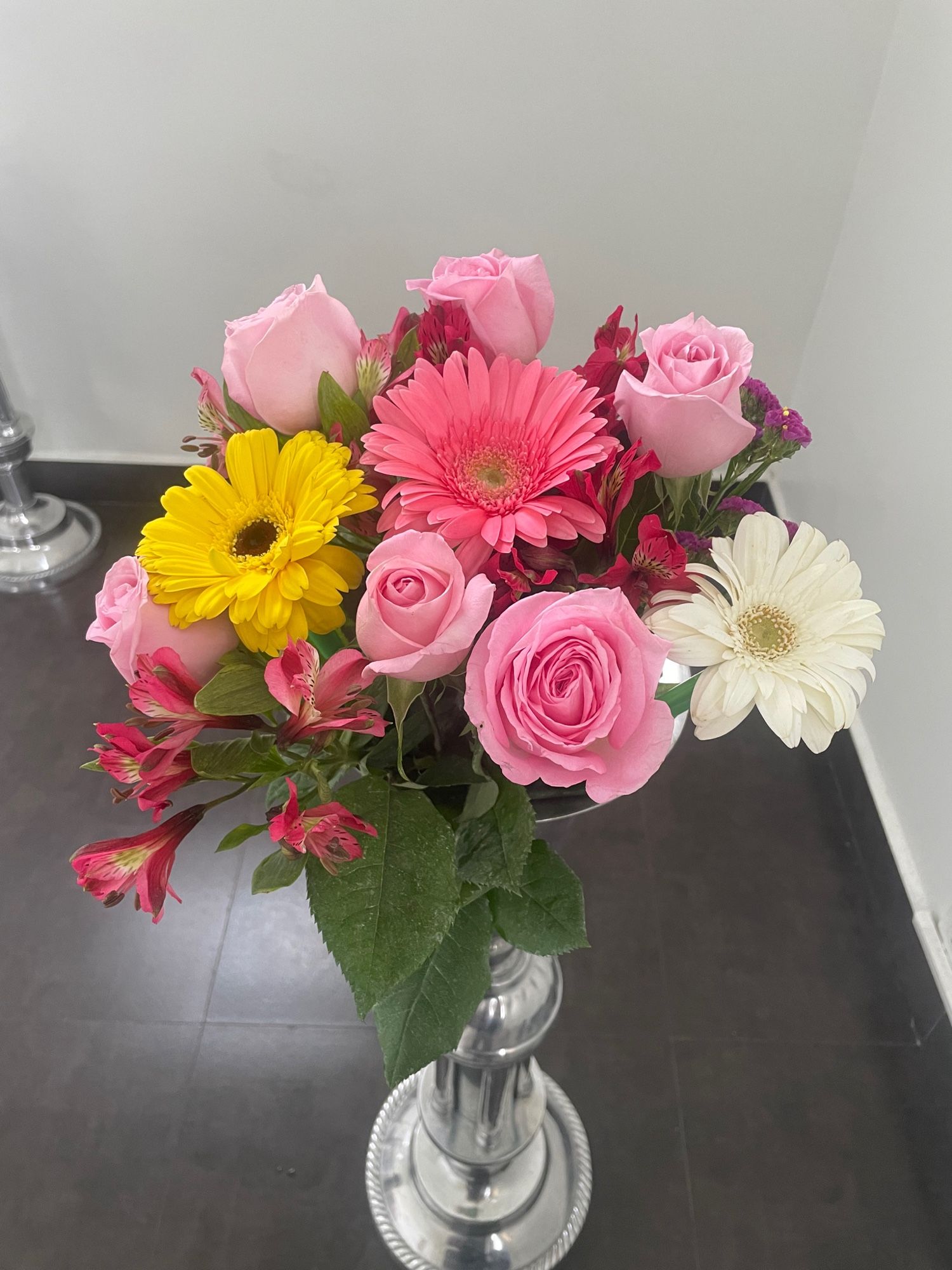 Bouquet of flowers in the funeral home. A mix of pink roses, pink-white-yellow gerbera daisies, and pink freesia.