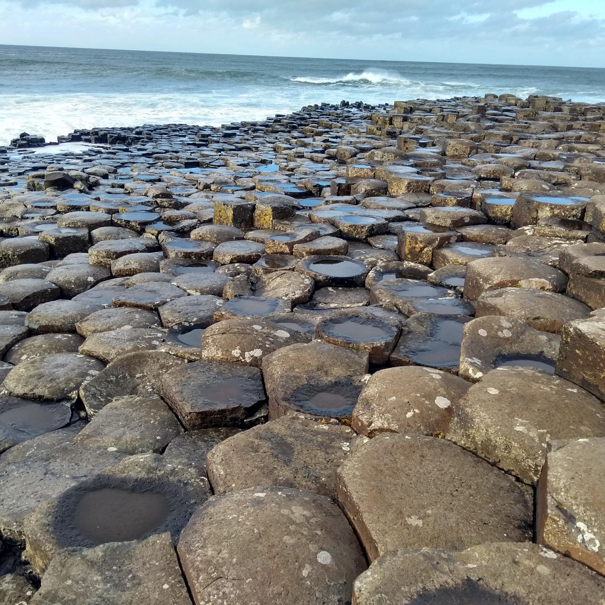 Photo of hexagonal columns of basalt extending out into the sea at the Giant's Causeway, N Ireland. Credit: Elliot Carter