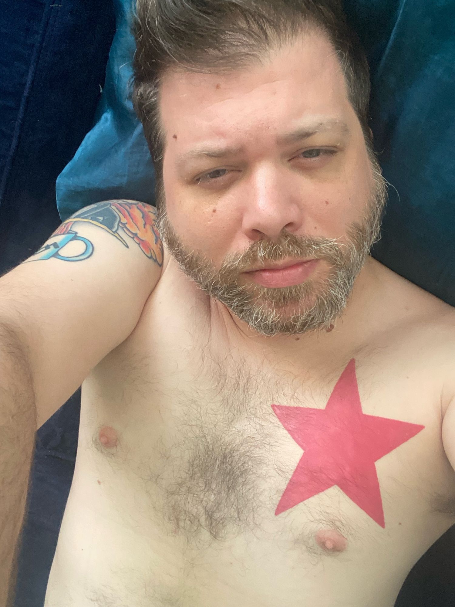 Selfie lying down, shirtless.