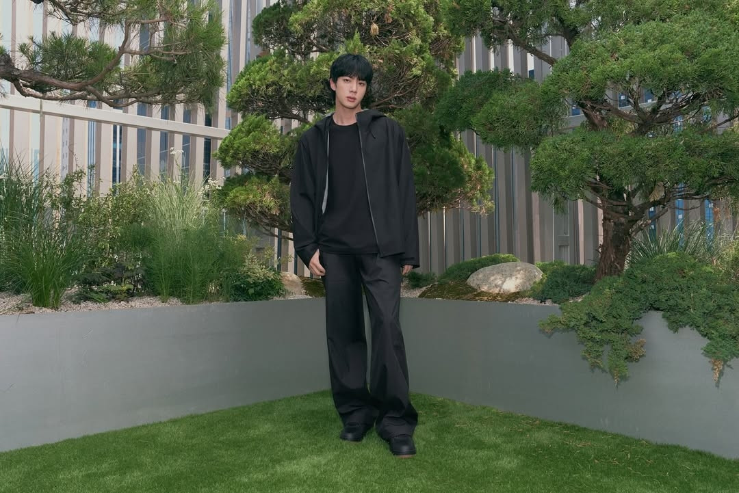 Photo of Jin wearing the same clothes and in the same place as the previous photo.
