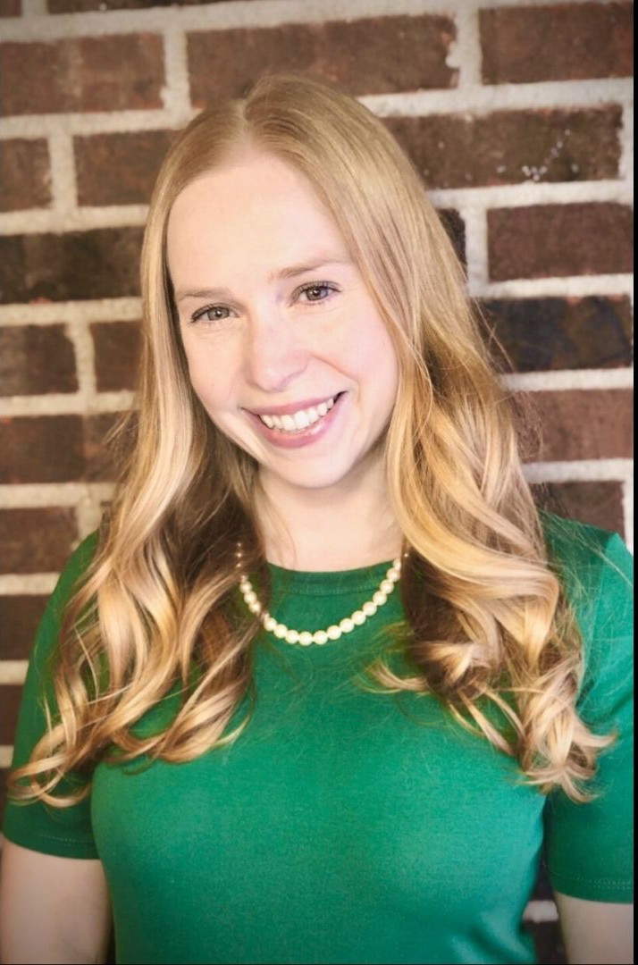 Photo of author Annie Sullivan standing in front of a brick wall.