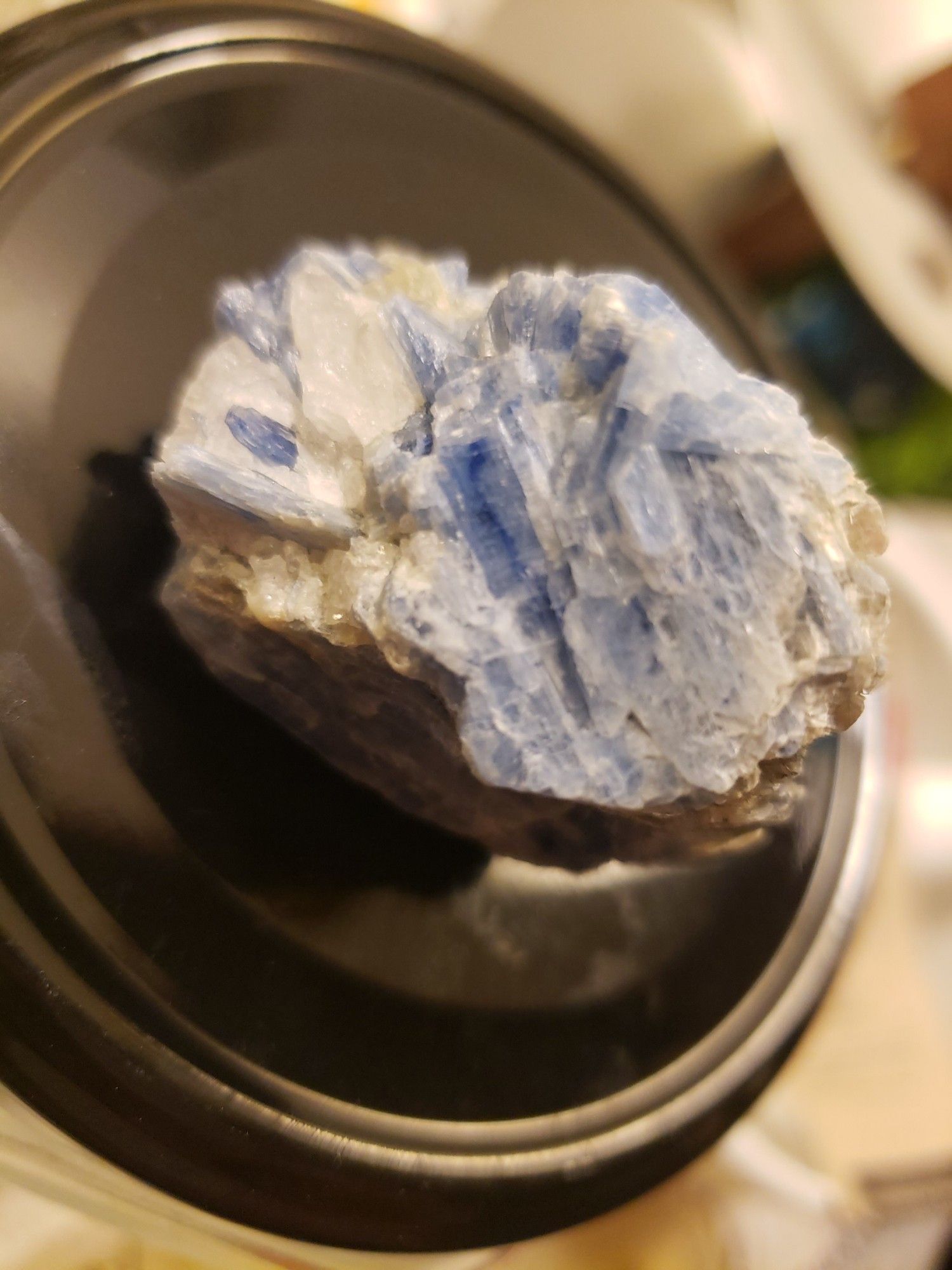 A close-up photo of Blue Kyanite showing varying shade of blue to white crystals.