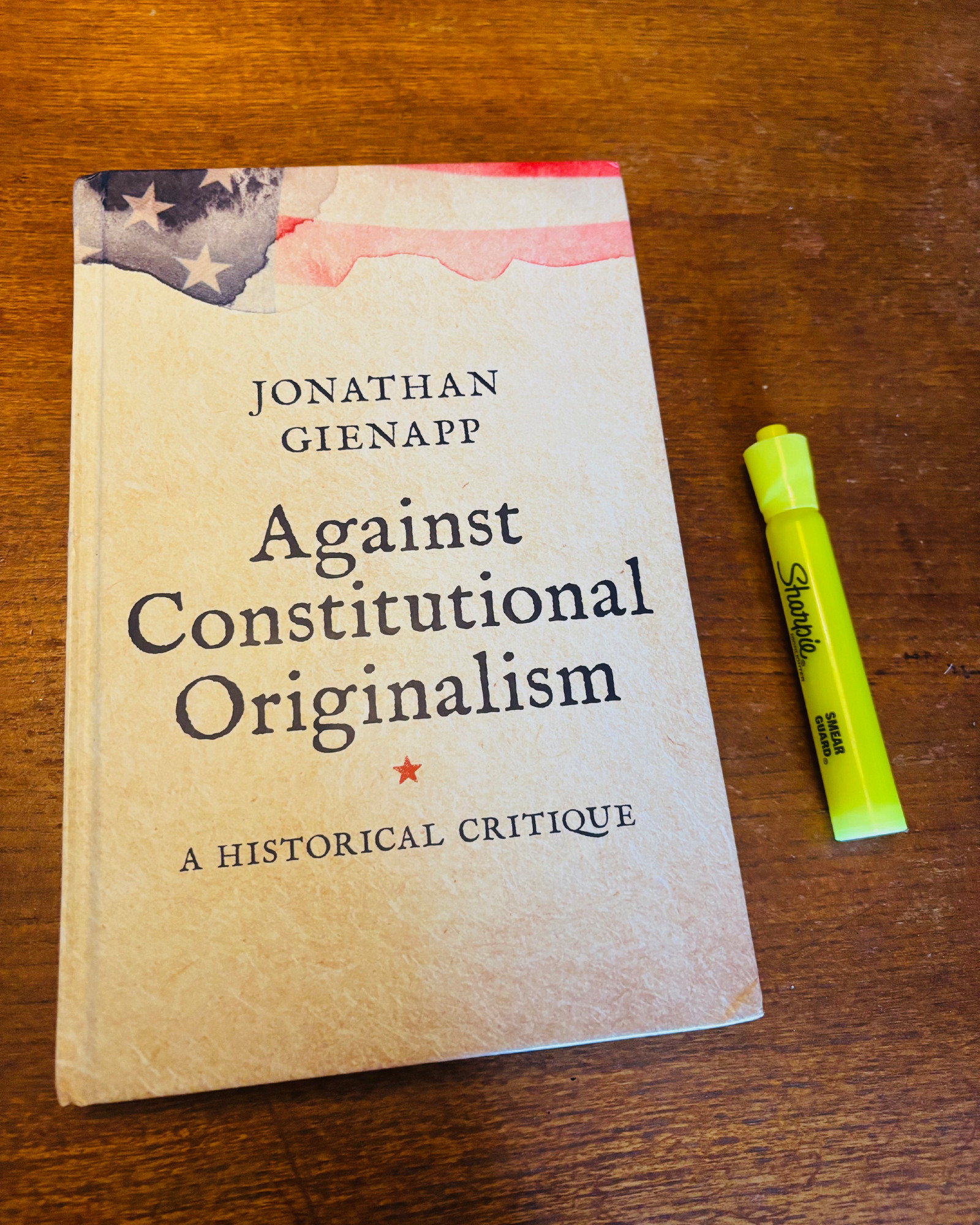 copy of Jonathan Gienapp's book Against Constitutional Originalism, A Historical Critique on a wooden table and a yellow highlighter marker next to it