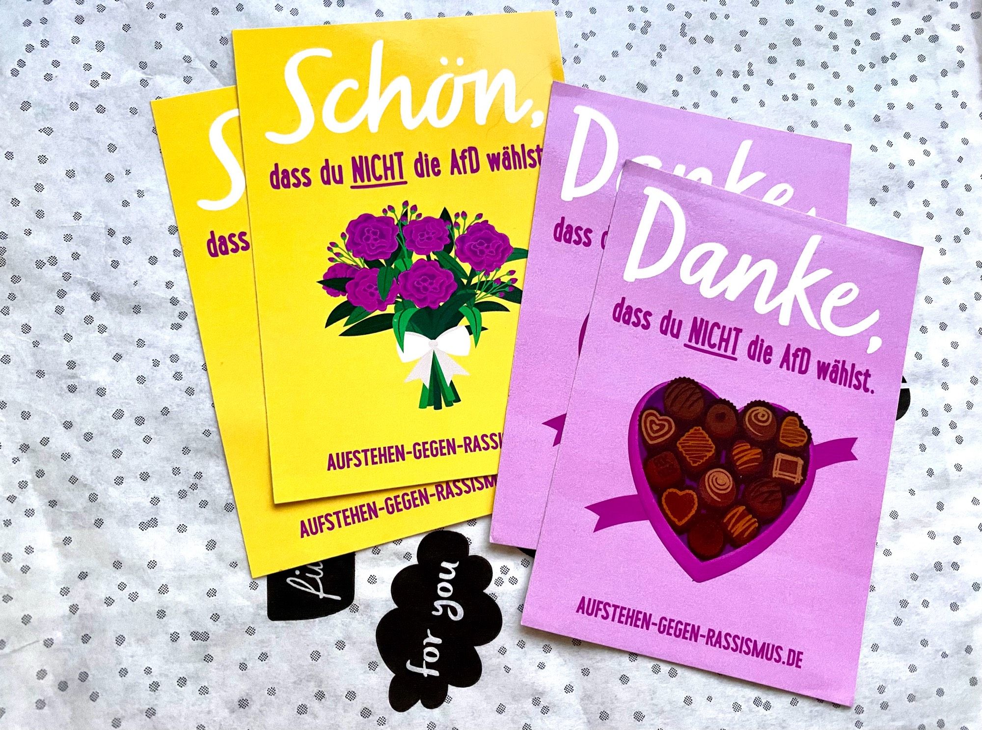 Vier Sticker der Initiative Aufstehen gegen Rassismus mit Blumenstrauß & Pralinenbox als Motiven