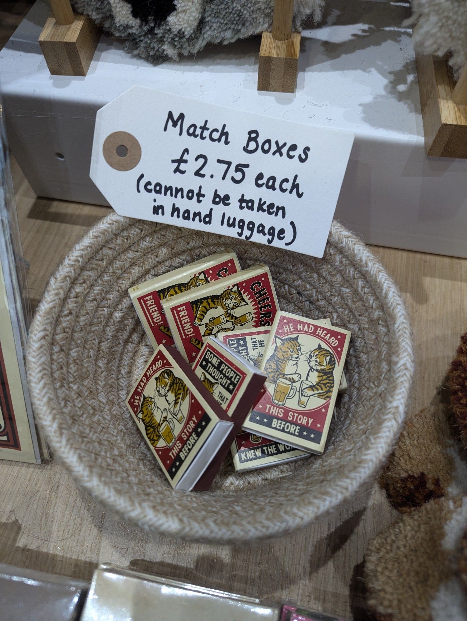 Fancy matchboxes for sale in a shop with a label that says "Match boxes £2.75 each (cannot be taken in hand luggage)"