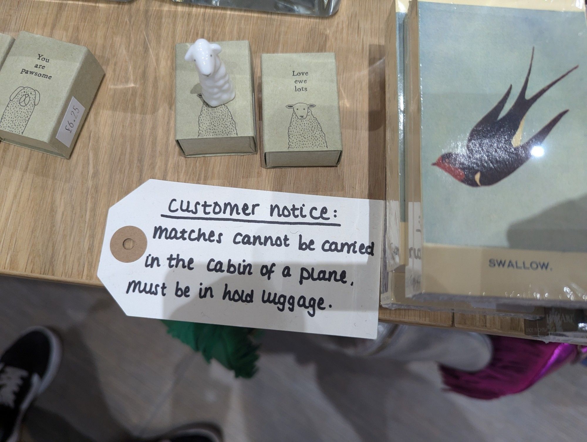 Fancy matchboxes for sale in a shop with a label that says "Match boxes £2.75 each (cannot be taken in hand luggage)"