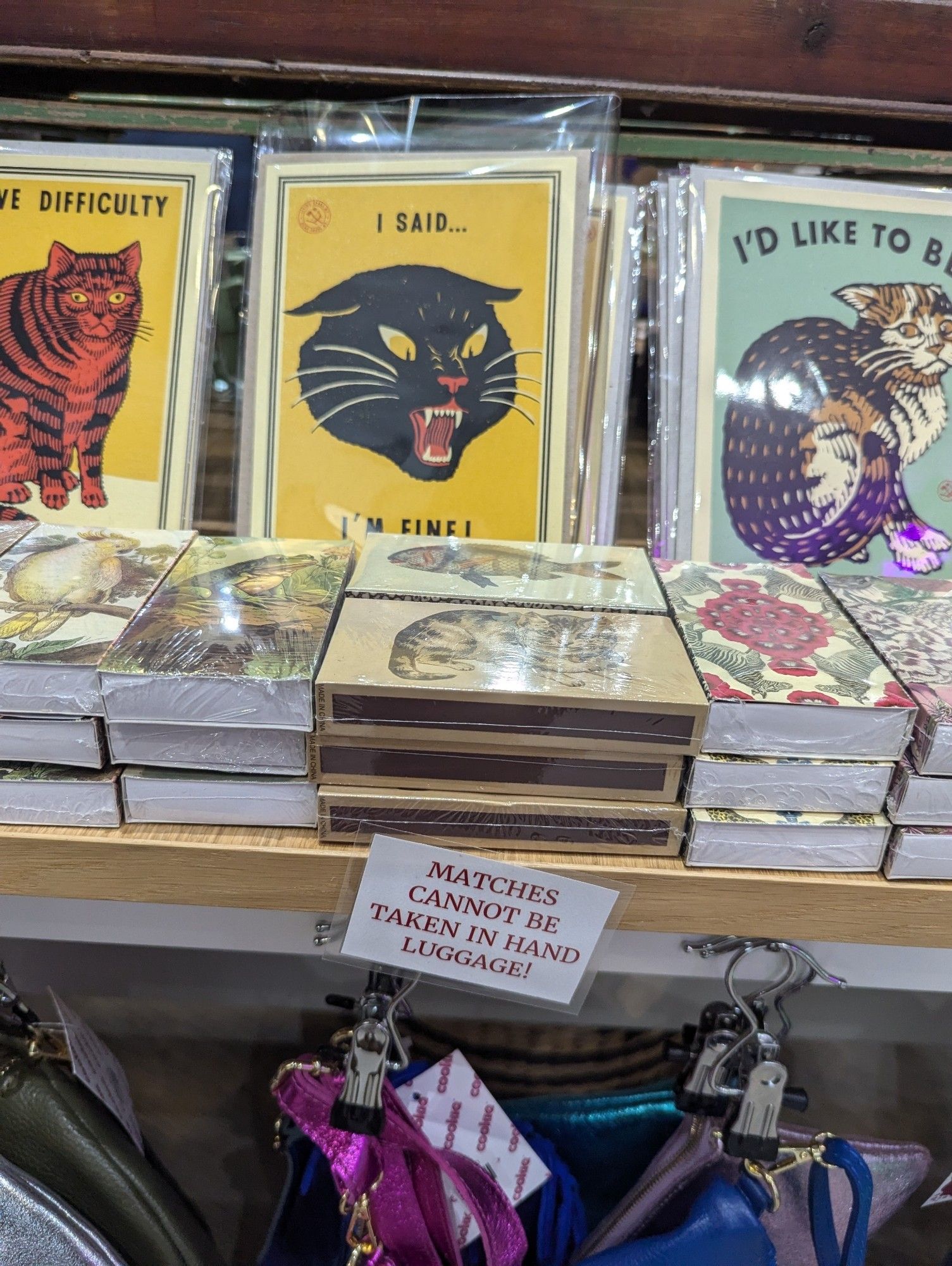 Fancy matchboxes for sale in a shop with a label that says "Match boxes £2.75 each (cannot be taken in hand luggage)"