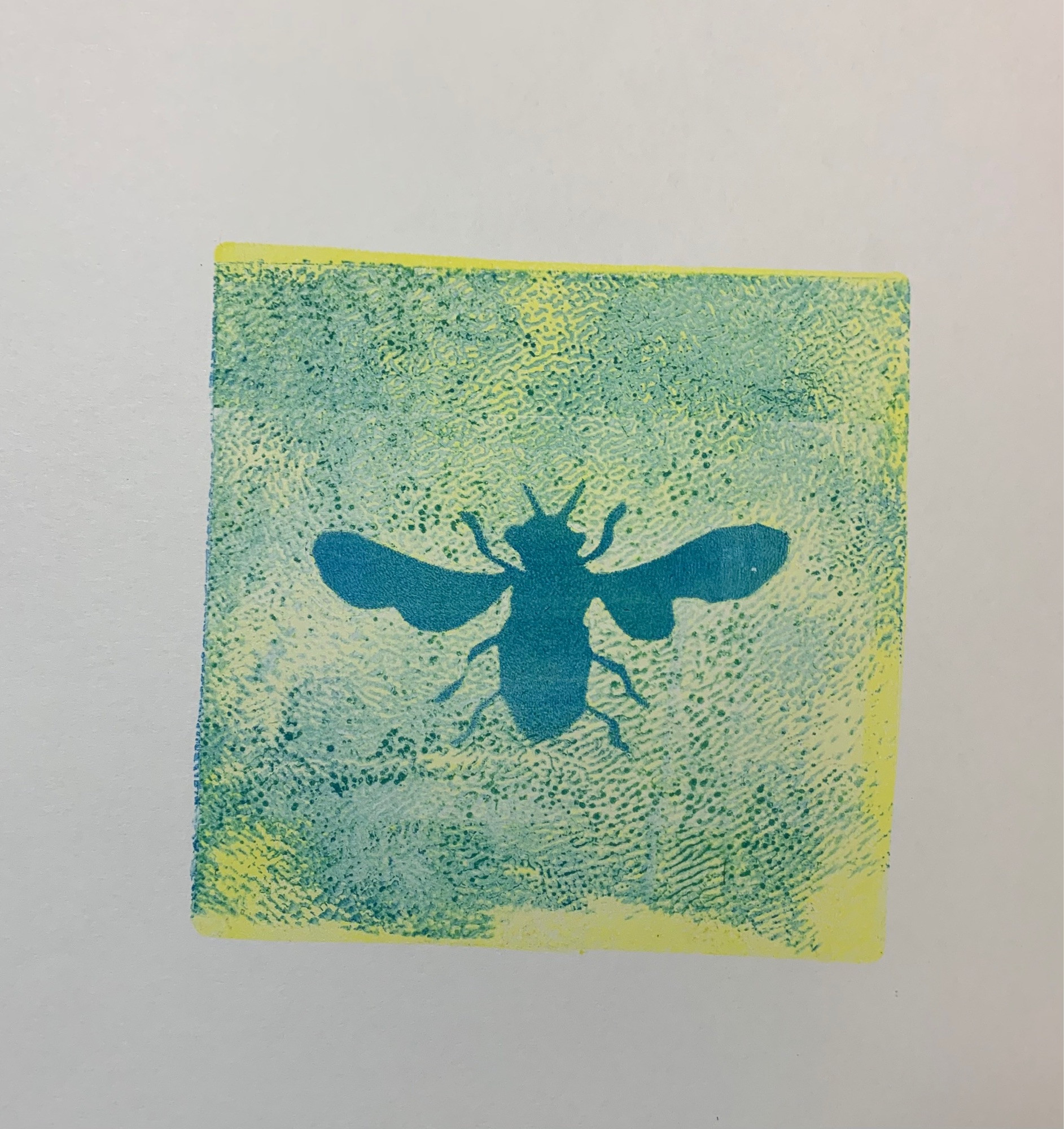 Green-yellow pockmarked background with a blue flying insect imprint in the middle.