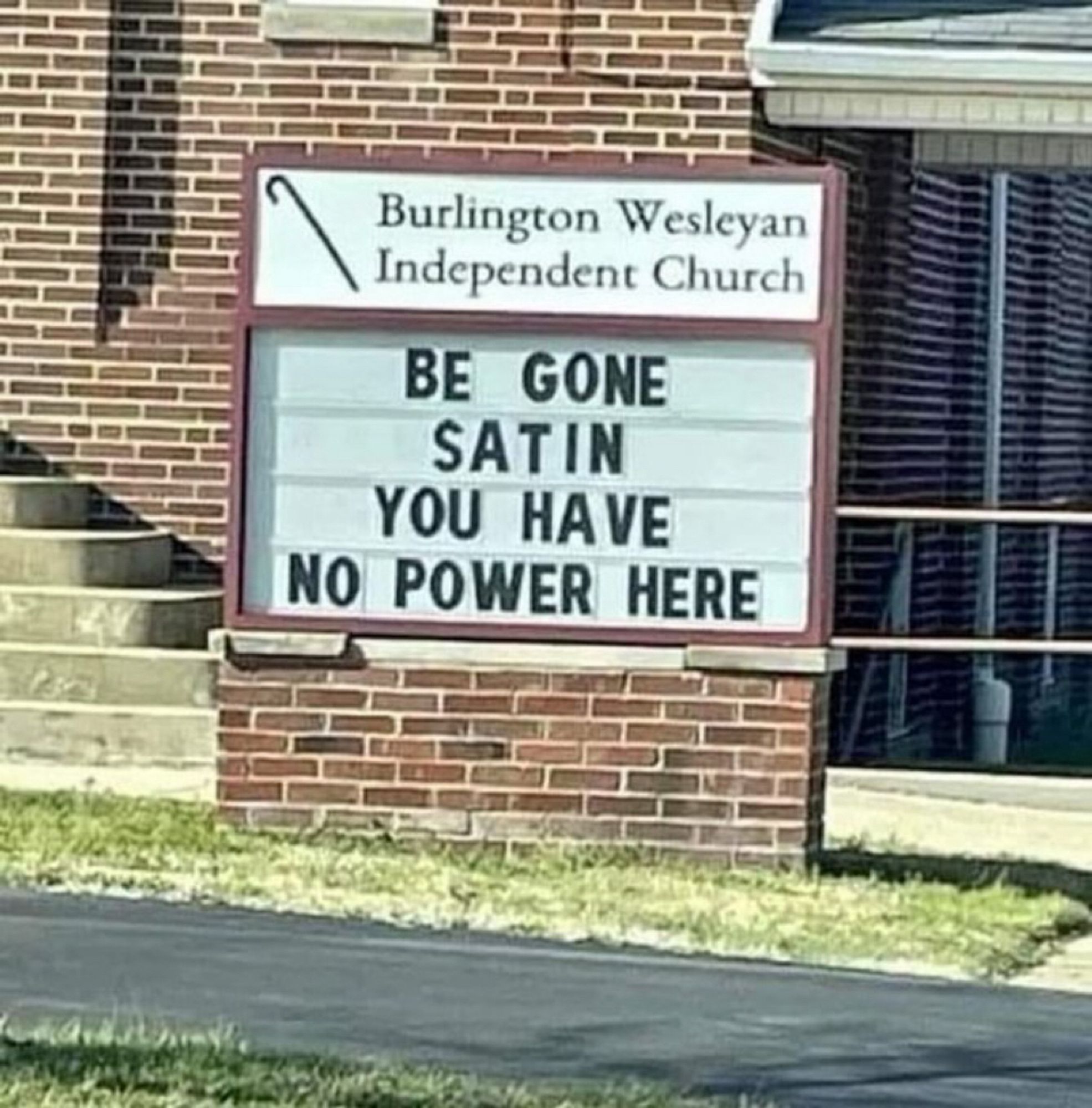 A sign in front of the Burlington Wesleyan Independent Church which states ‘Be gone satin you have no power here’