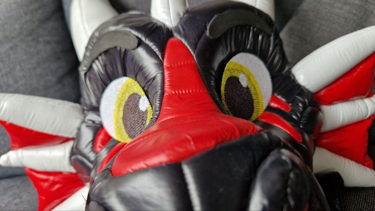 A closeup of NyFi, the shiny nylon dragon, with brand new eyes made by Volf