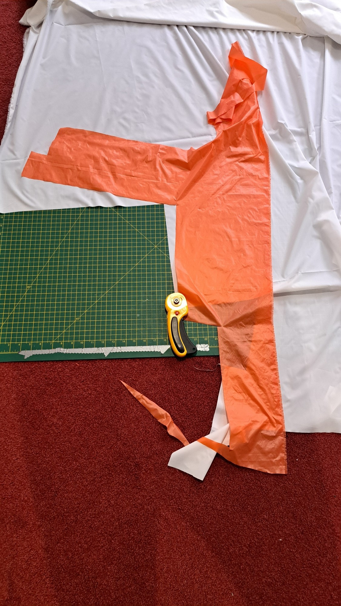 A piece of orange nylon fabric on a cutting mat