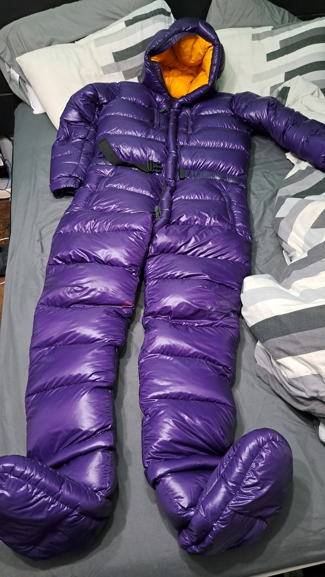 A shiny nylon downsuit with a purple exterior and yellow lining