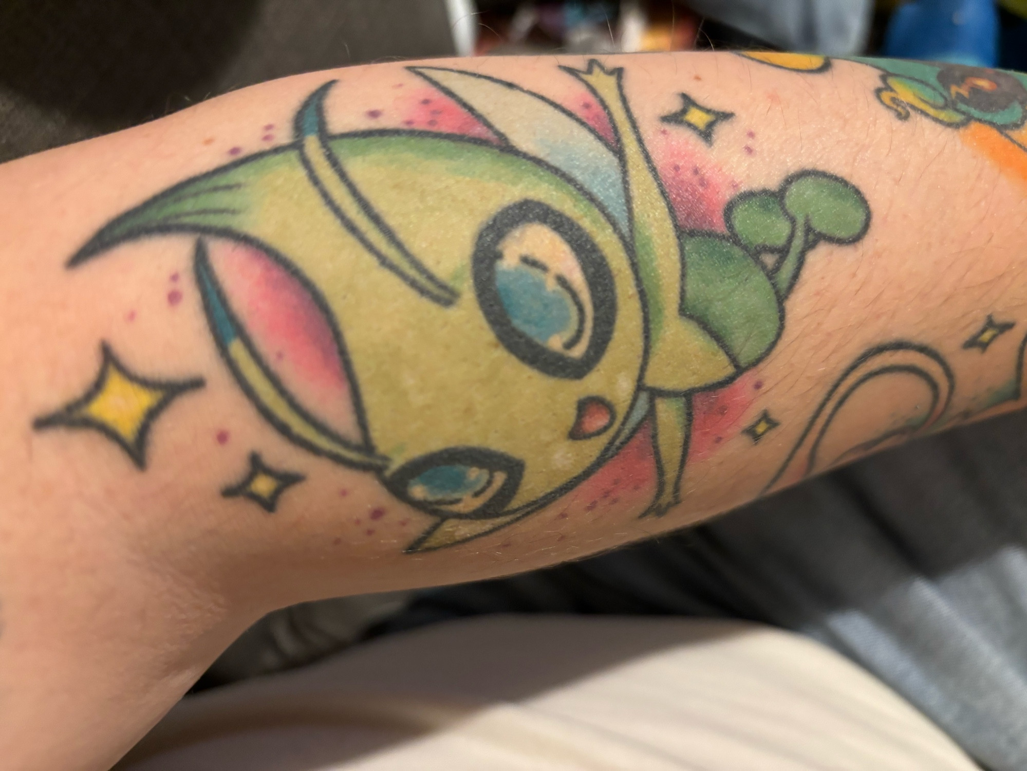 A landscape orientation picture of a Celebi tattoo