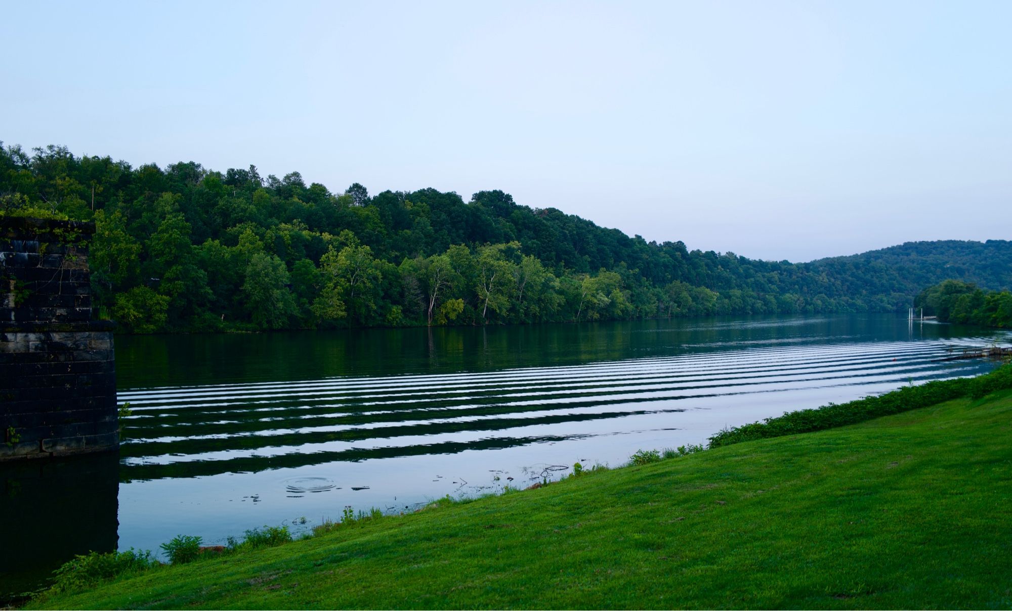 Ripples from a boat’s wake on a calm river surface; Monongahela River, Coal Center, PA.