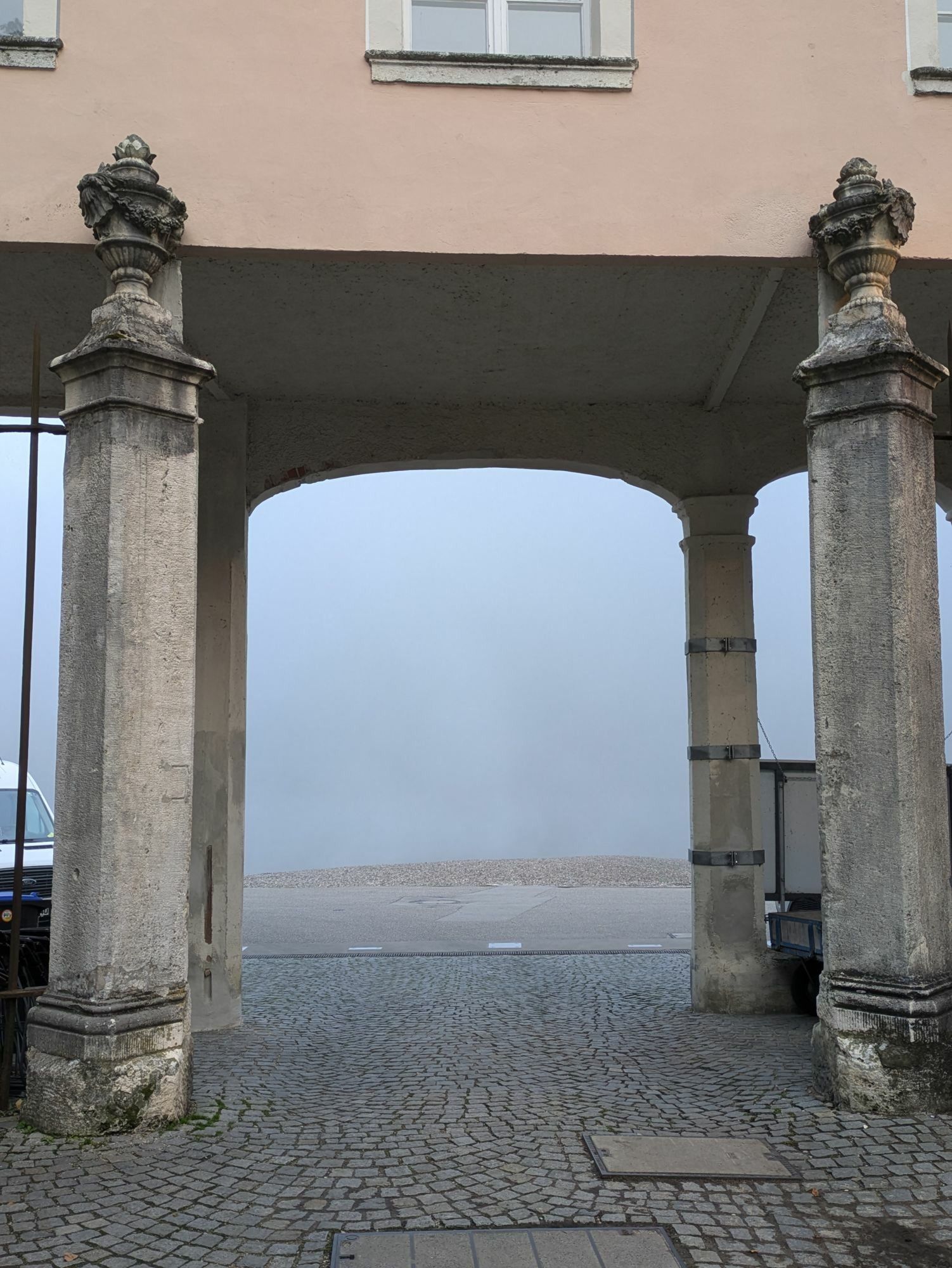 eine Tordurchfahrt hinter der nur grauer Nebel zu erkennen ist 