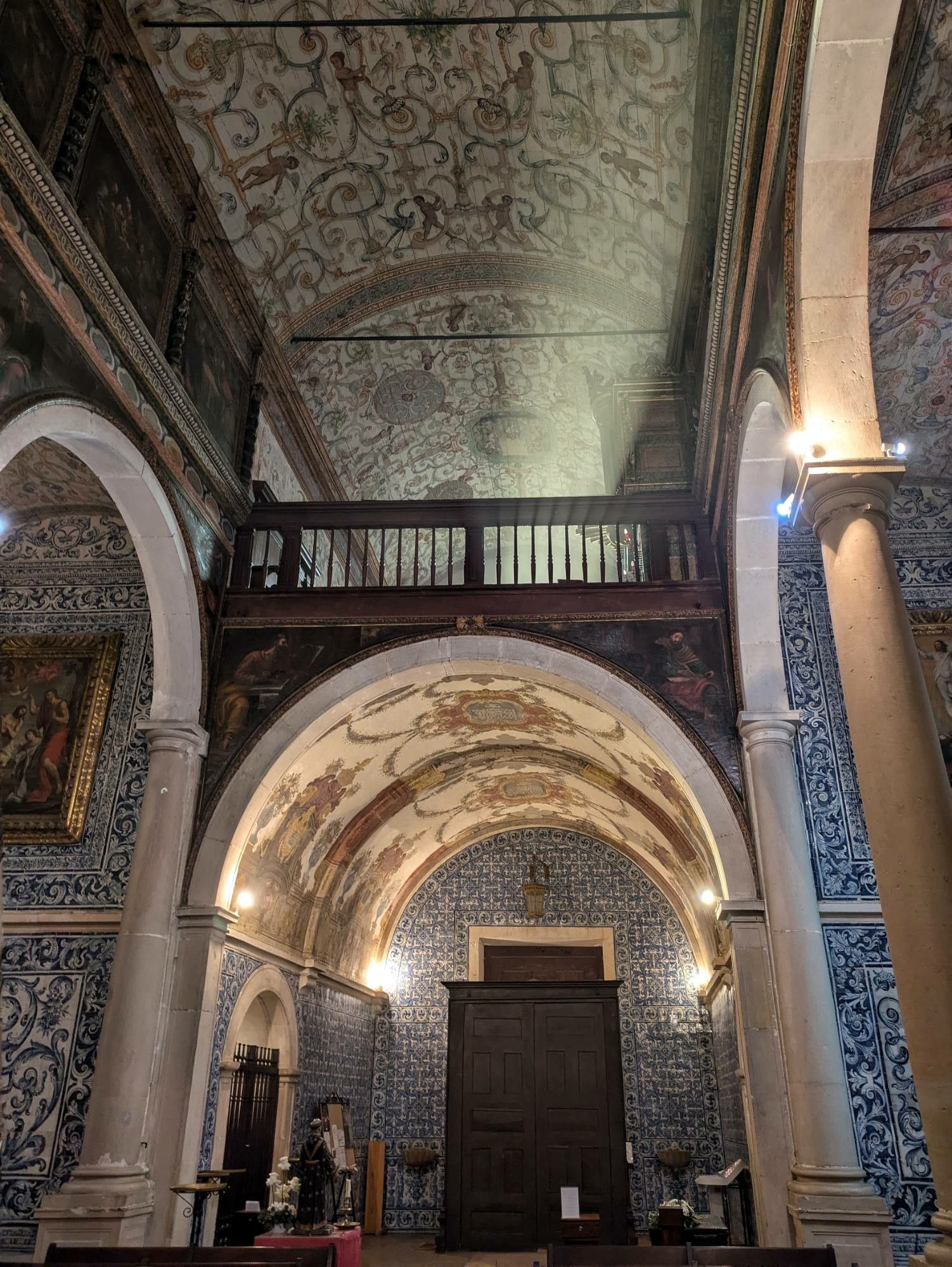 eine Kirche mit einem Bogen über dem Eingang und der Empore drüber. Der Sonnenstrahl ist gut zu erkennen, weil er den "Weihrauchnebel" beleuchtet 