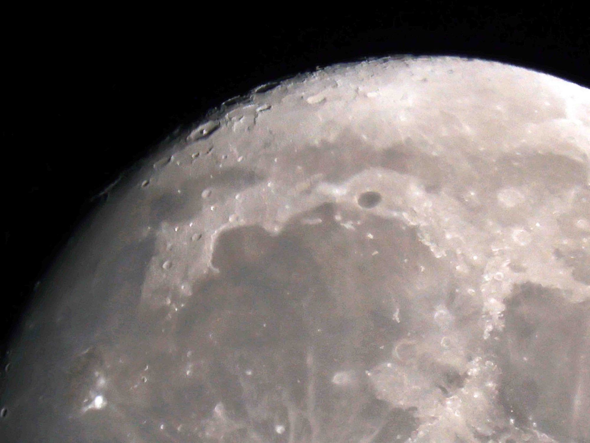 Detail of the top/right of the waxing moon, craters are only clearly defined by the shadow line.