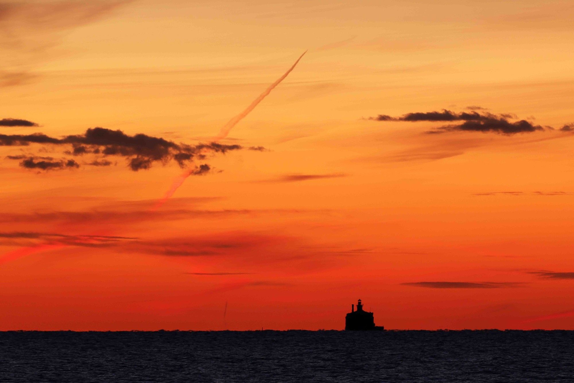 Lake Michigan Water Crib with predawn red and orange skies behind it.