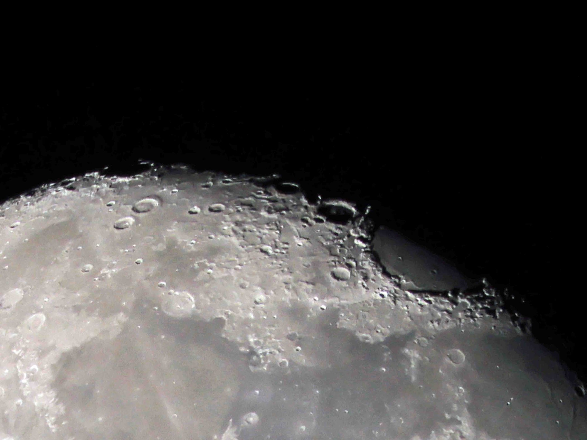 Detail of the very top of the waning gibbous moon. Large crater/ridge line is very clear near the right side. 