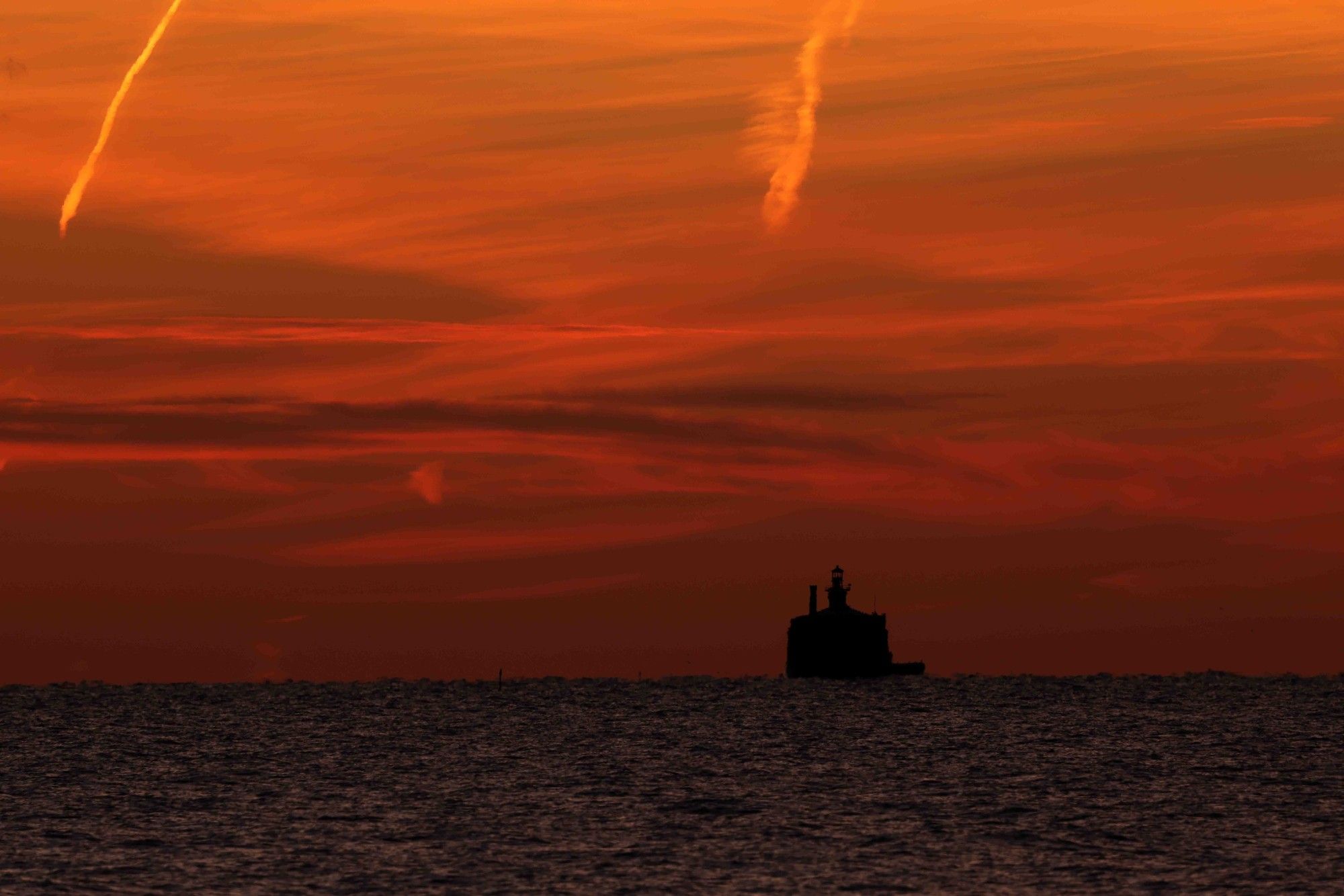 Lake Michigan Water Crib with predawn red and orange skies behind it.