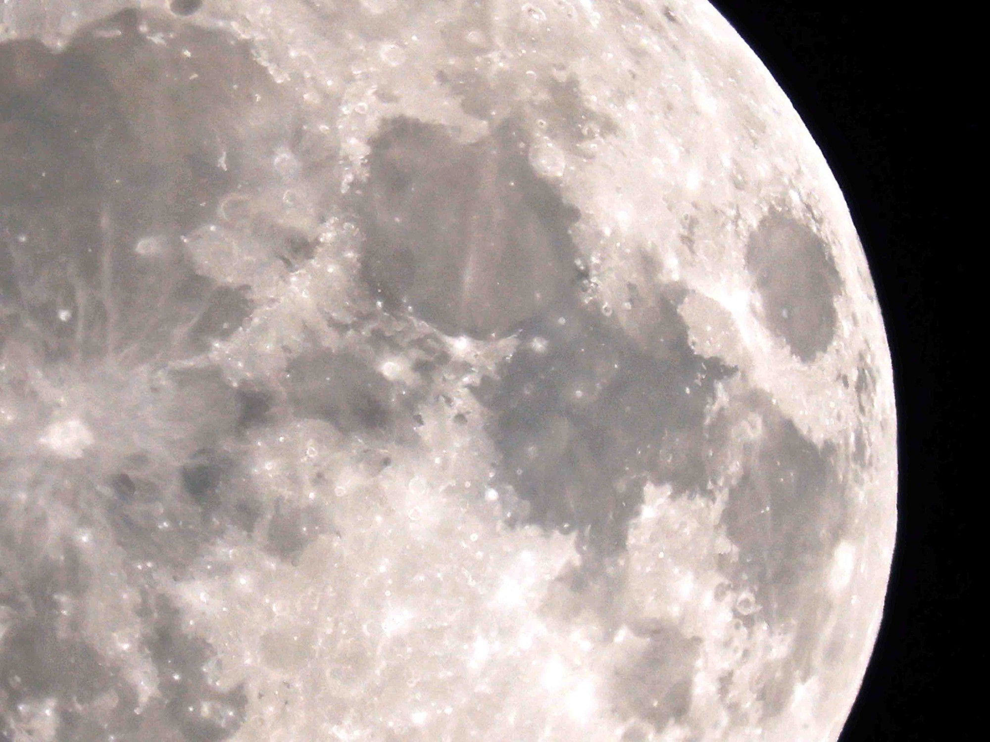 Detail of the center/left of the waxing moon, the outline of some craters are visible but for the most part it looks flat (it isn't).