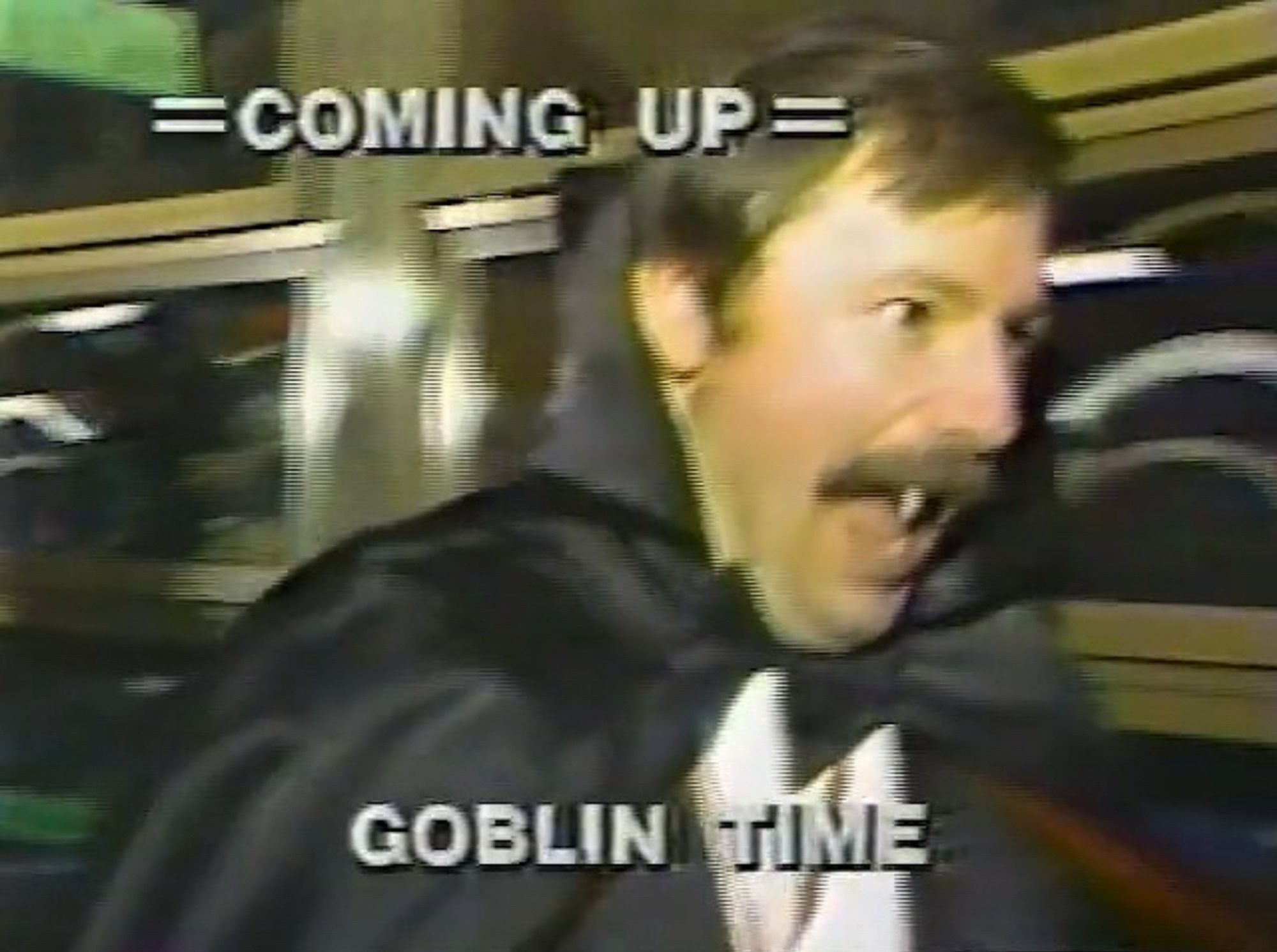 A vintage tv screenshot of a white hit with a mustache dressed like a Dracula with his mouth open to show fangs. Text over the image reads: 
= COMING UP=
GOBLIN TIME