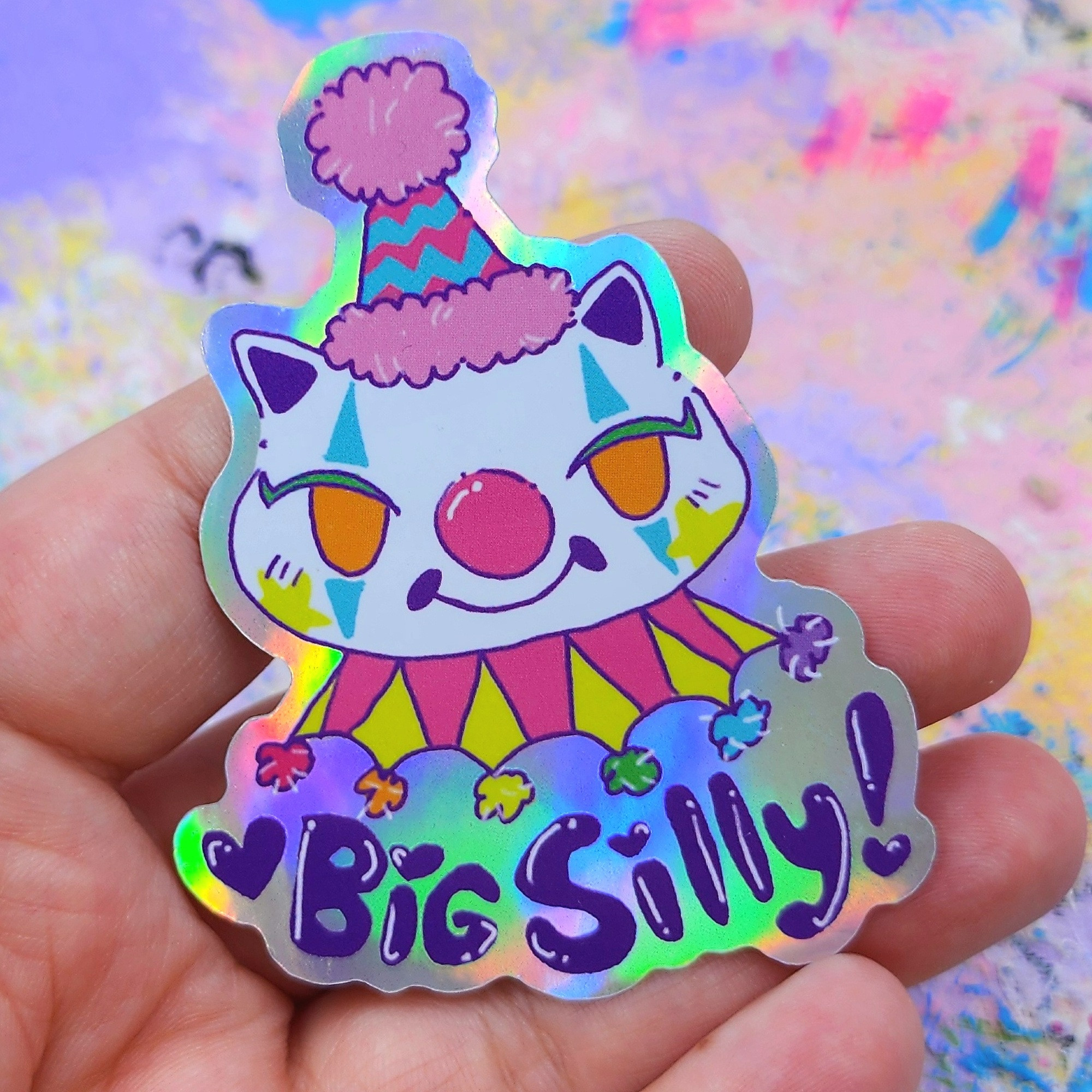 A sticker of a white cat with clown makeup. The text says: big silly! 