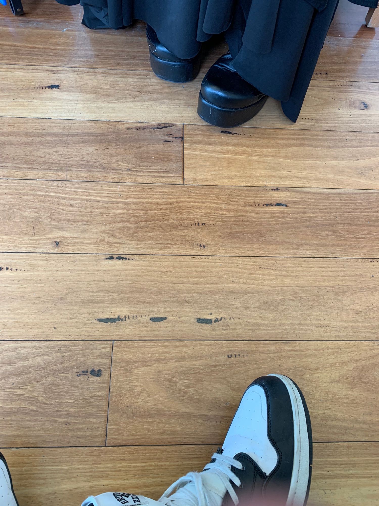 The shoes of two different people sitting across from each other in a doctor’s office.