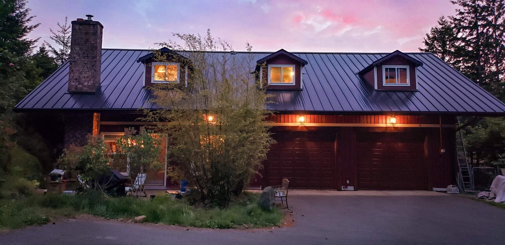 Forward Operating Base Malik at sunset. A converted barn with a steel roof and dormers, and a brick chimney jutting from one end.