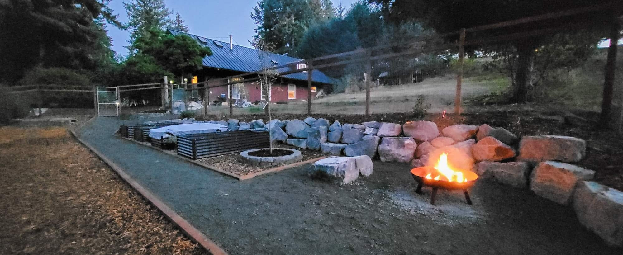 The garden at sunset, looking back toward the house. A fire burns in a firepit.