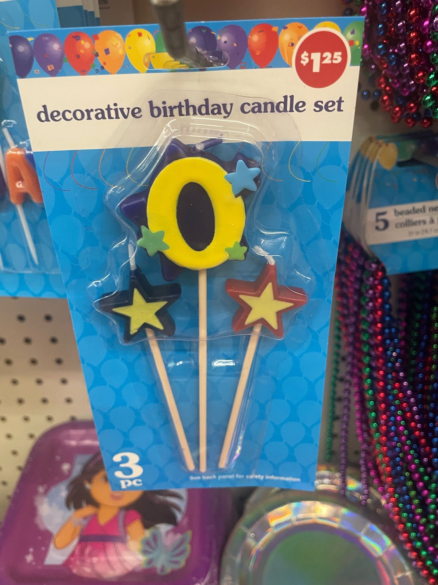 Image of a package of birthday candles on a rack at a store. The number on the candle is zero.