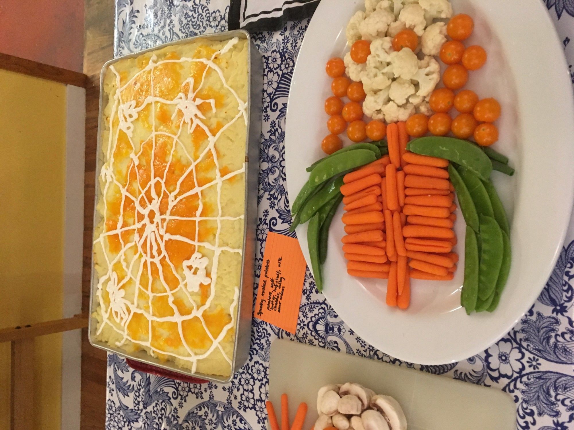 Another skeleton-shaped platter of crudités (cauliflower, cherry tomatoes, baby carrots, pea pods); "spooky mashed potatoes" (a large roasting pan full of baked cheddar mashed potatoes, topped with a large spider web and spiders drawn in sour cream).