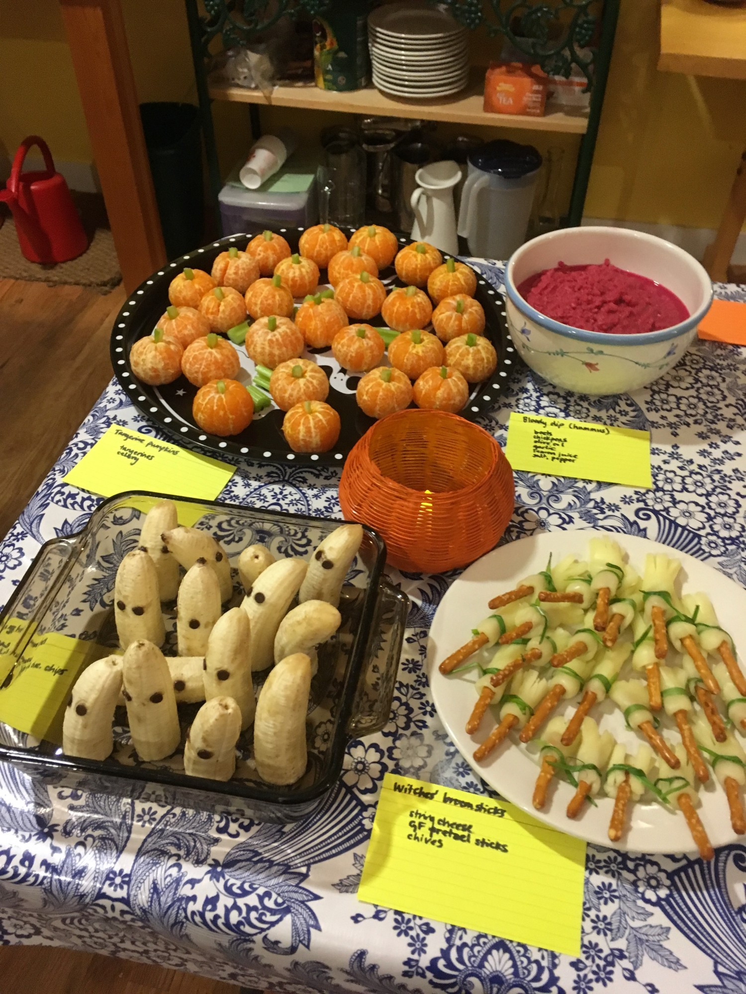 Tangerine pumpkins (tangerines with celery stems); ghost bananas (half-bananas with chocolate-chip eyes); bloody dip (beet hummus); witches' broomsticks (pretzel sticks wrapped with string cheese and chives)..