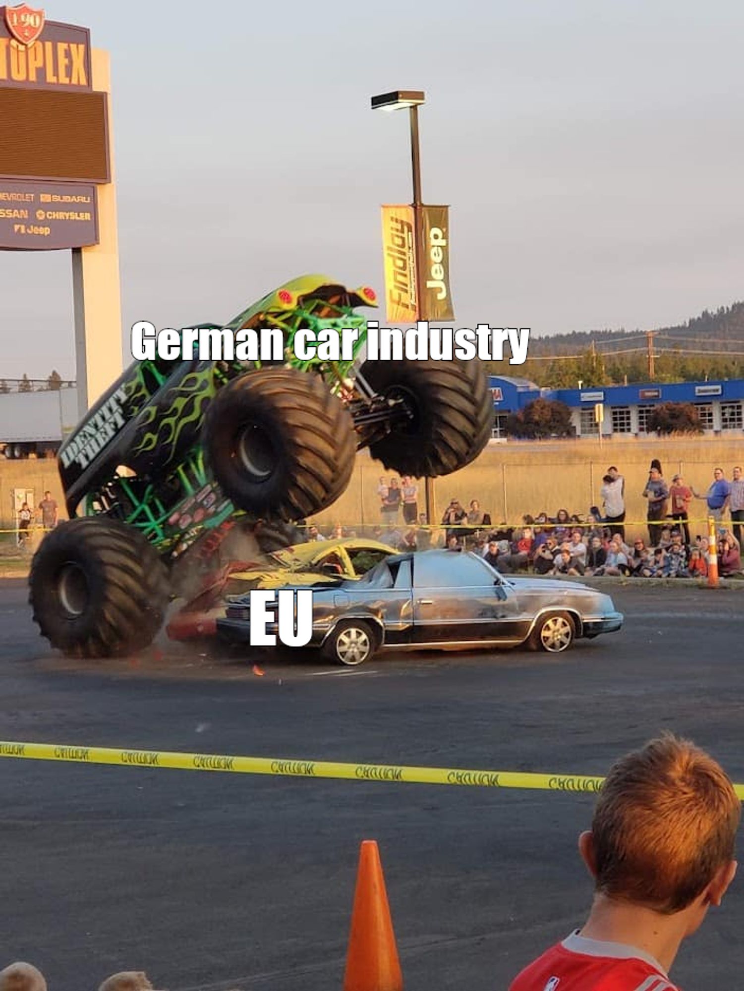 Monster truck about to slam down on a car.
 The slammer is labeled with German car industry and the person or thing being slammed is labeled EU.

 image source: https://di-uploads-pod11.dealerinspire.com/findlaychryslerjeepdodgeram/uploads/2021/07/car-crush.jpg