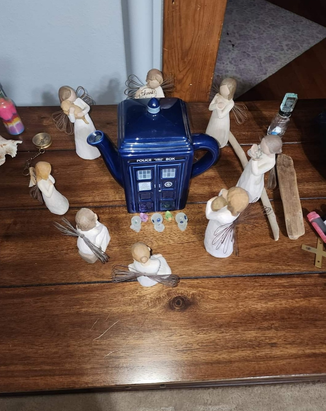 Picture is of a TARDIS from Doctor Who surrounded by angel figures facing towards it.