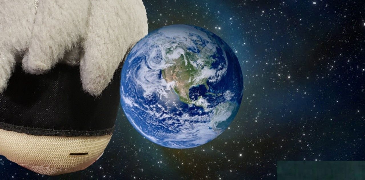 The head of a plush of the character 9S from NieR: Automata is edited into a picture of Planet Earth where it seems that he is approaching and dwarfing the planet. Very scary 😨