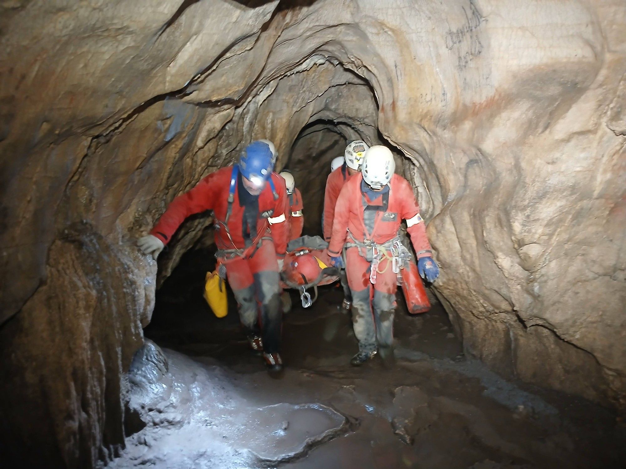 Les sauveteurs portent la civière dans la grotte