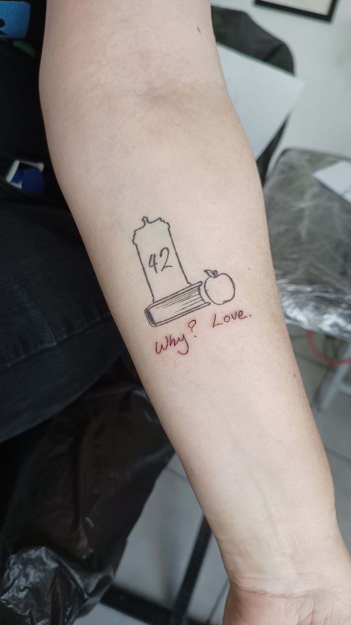 A tattoo with a TARDIS, Douglas Adams' 42, the book and the apple from Good Omens and Neil Gaiman's quote in his handwriting