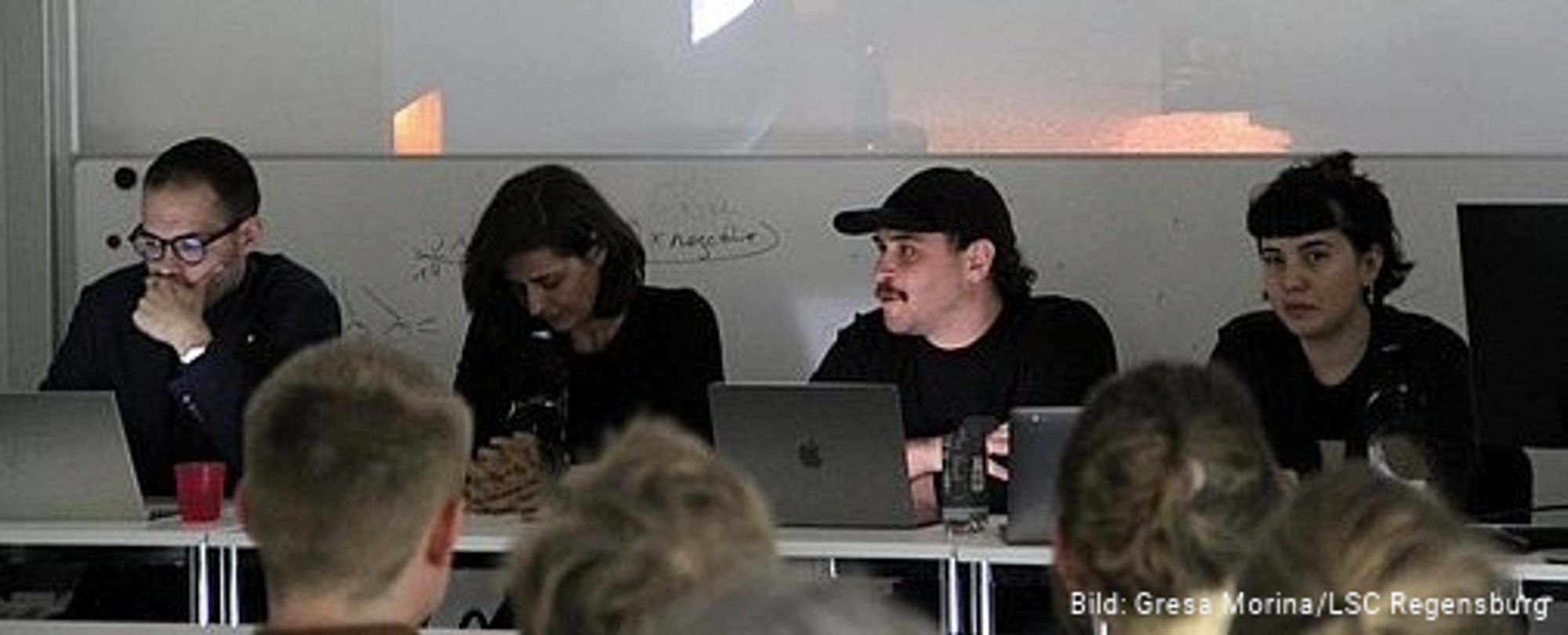 Artists from the collective siting on a panel during the public discussion.