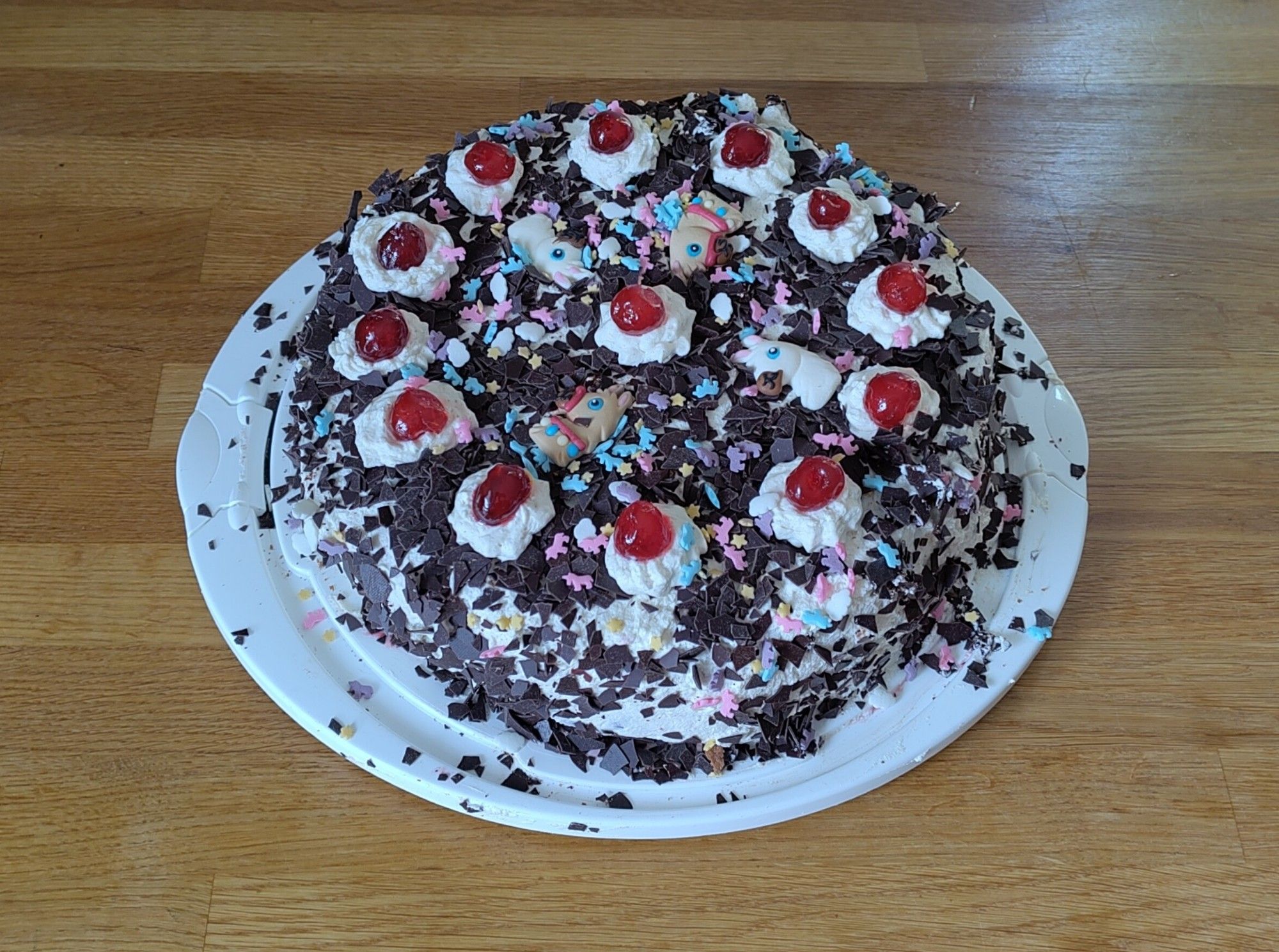 Schwarzwälder Kirschtorte mit Einhorn-Dekoration und Pferden