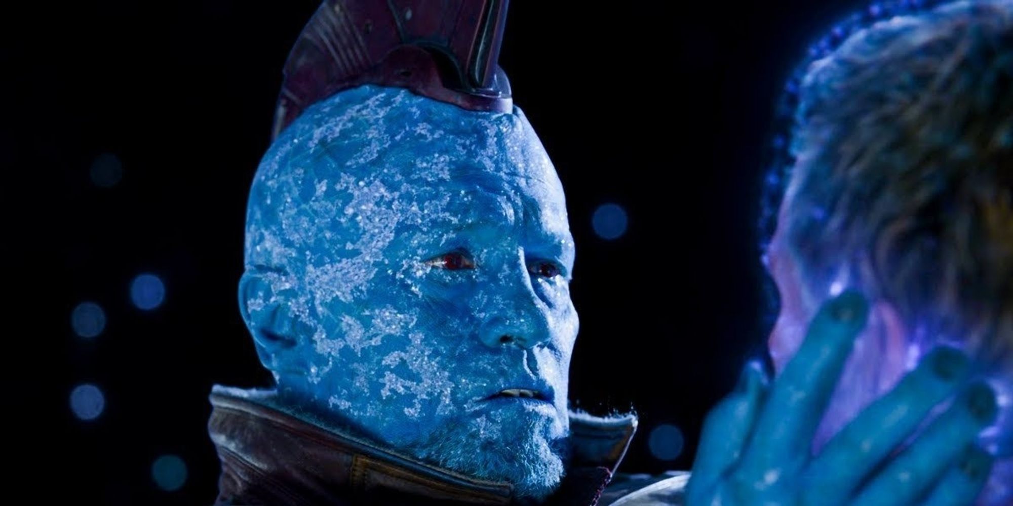 Yondu from Guardians of the Galaxy embracing Peter Quill's face as Yondu dies in the vacuum of space 
Yondu is a blue skinned humanoid with a mohawk played by Michael Rooker