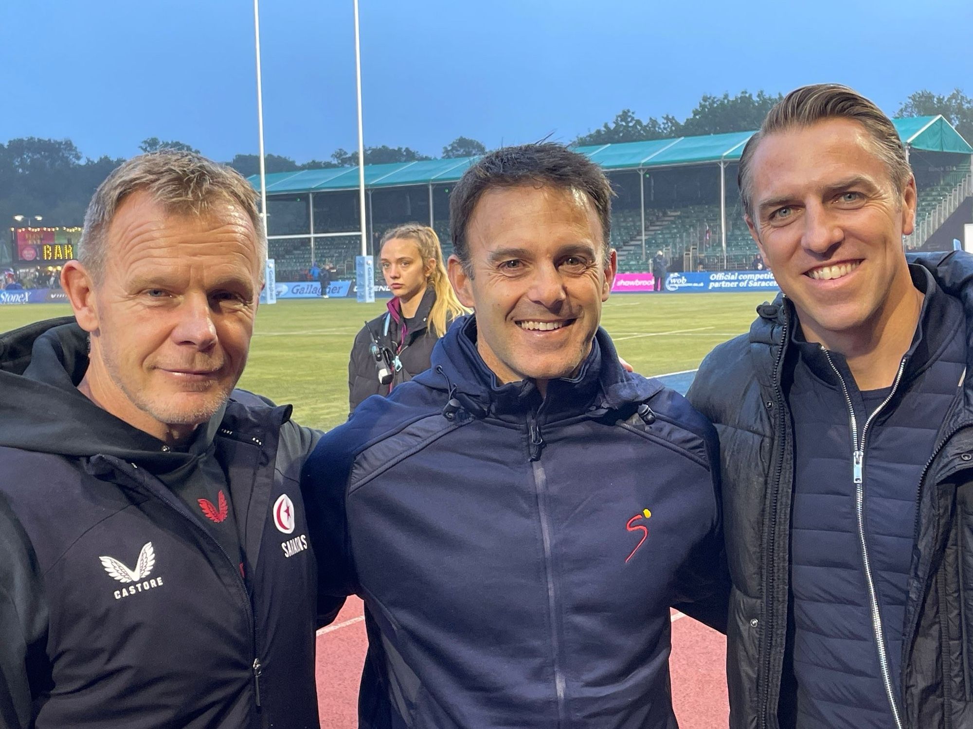 Photo of three people linking arms: Mark McCall, Neil de Kock and Chris Wyles. All Saracens legends.