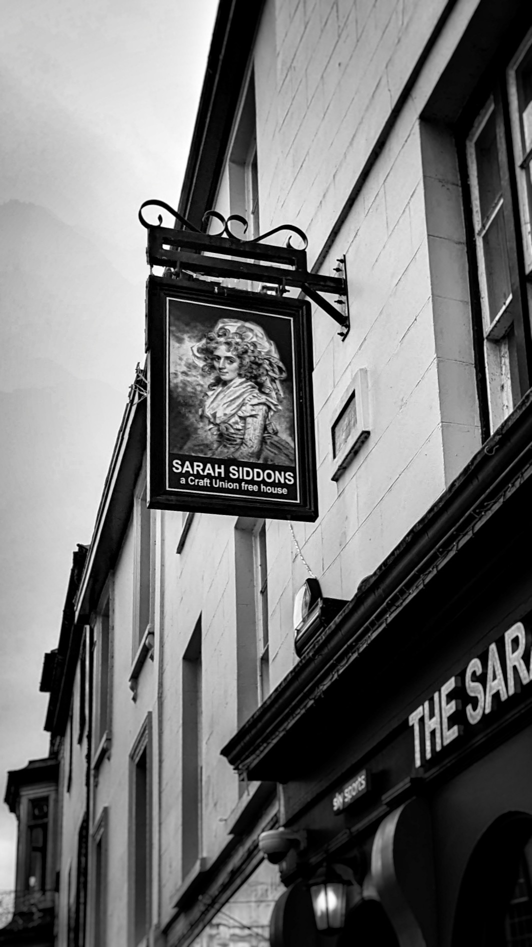 Up on the street side hangs the 'Mary Siddons Inn' sign. Photograph is in black and white