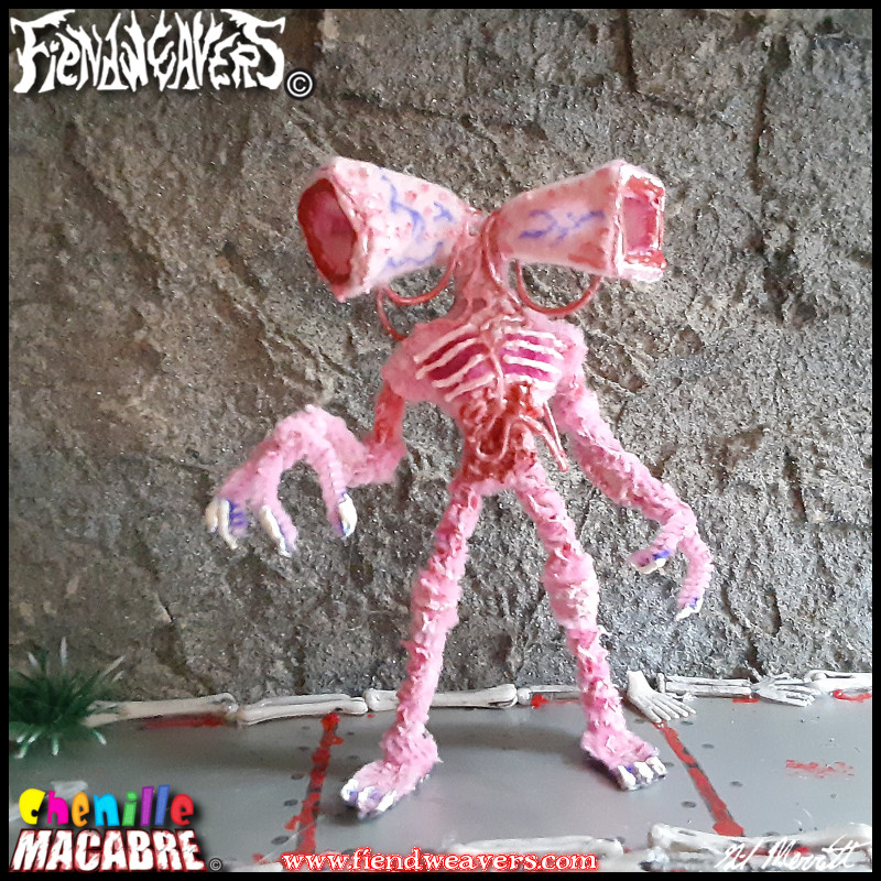 A pipe cleaner figure I built of the creepypasta Siren Head. It is a tall, gaunt, pink humanoid with two sirens for a head.