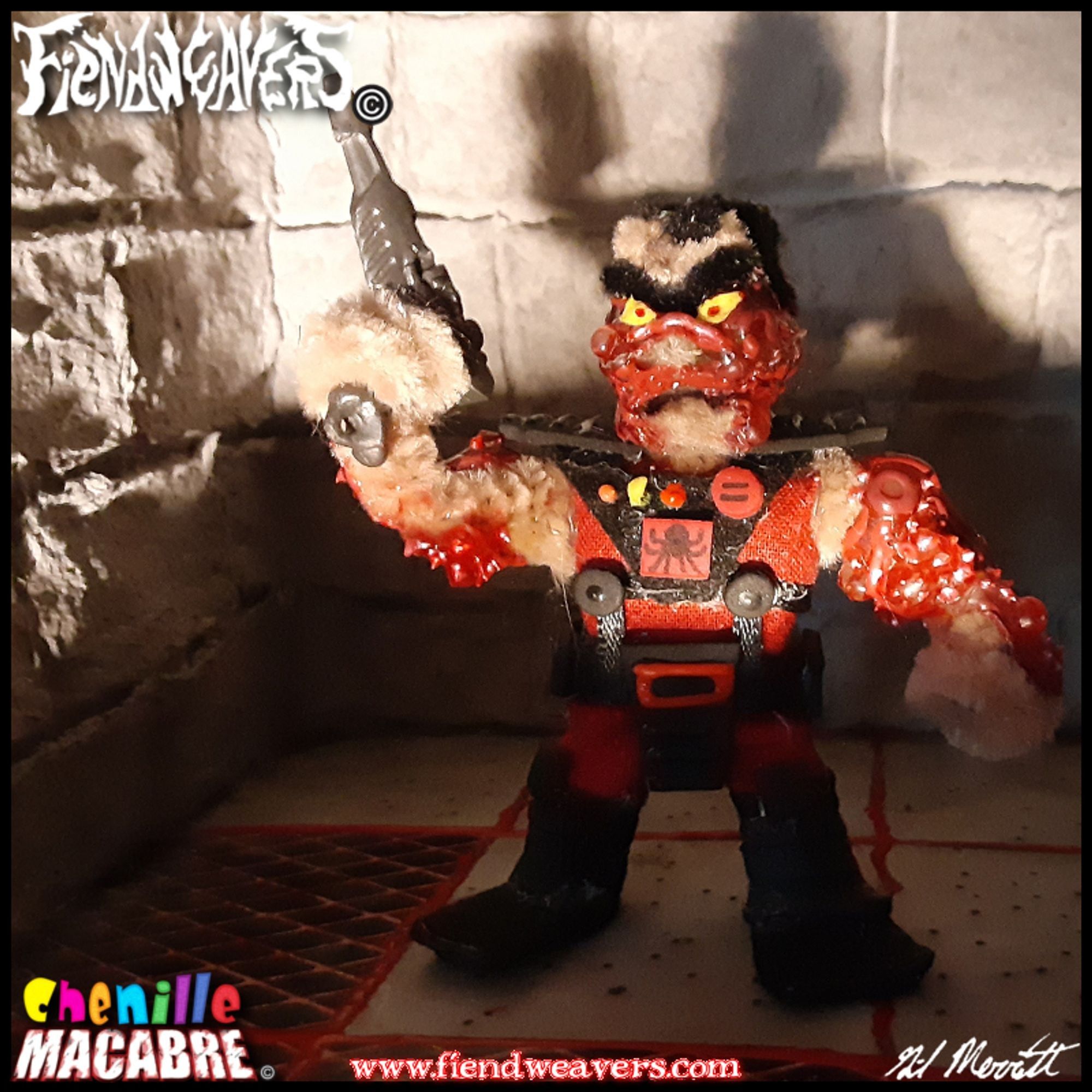 A pipe cleaner figure I built of Overlord from the cartoon SPIRAL ZONE, with the helmet off. Overlord wears red-and-black combat fatigues. His body is covered in boils. He stands 3" (7.62 cm) high and his arms and head are removable for AMPUTHEATRE combat.