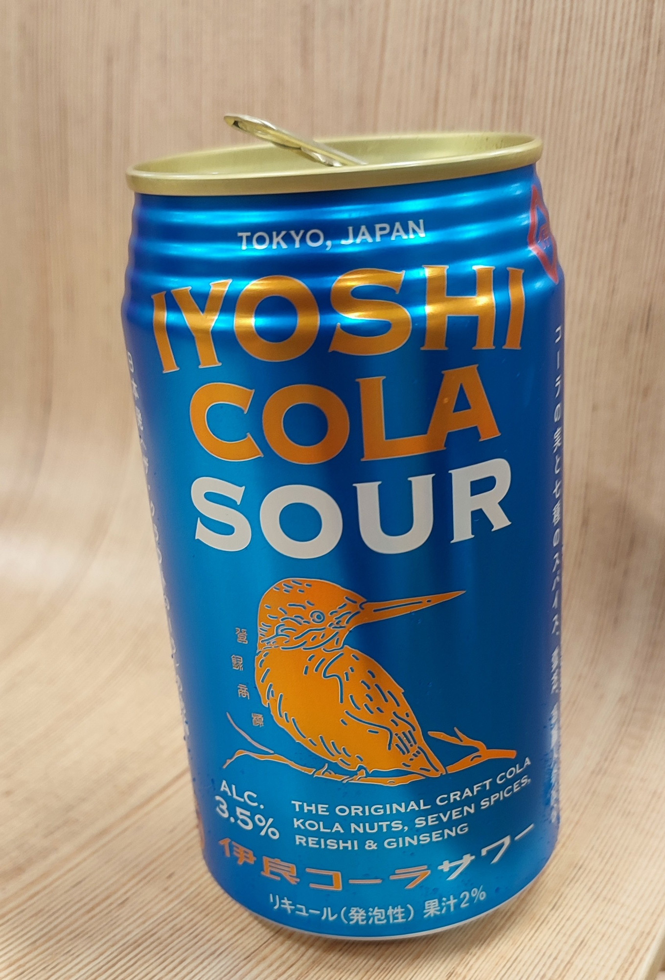 「伊良コーラサワー」の缶。
青字の缶に「IYOSHI COLA SOUR」とカワセミのロゴが描かれている。