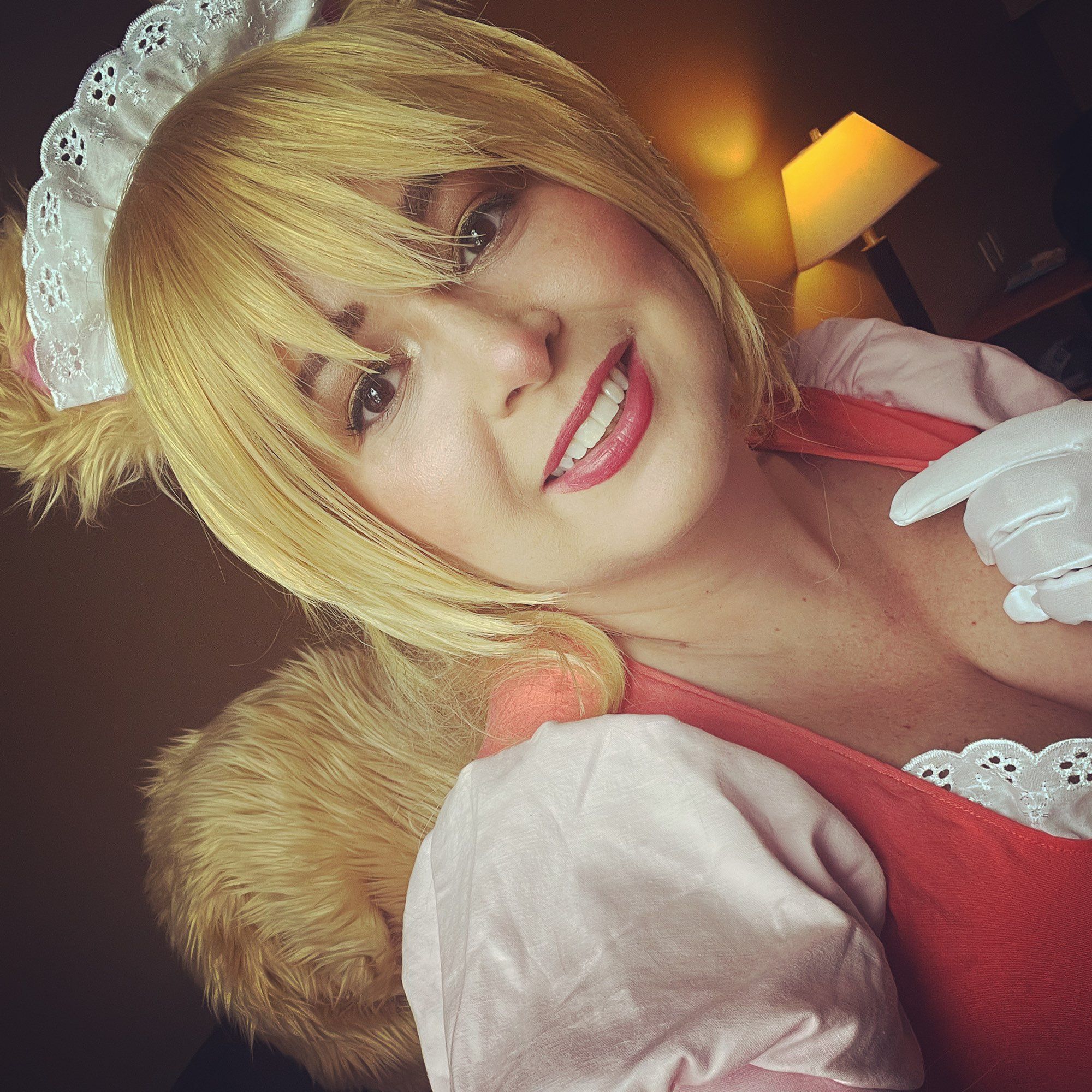 Jenna dressed by as Greta Fallah from the video game, Witchfall. Blonde hair, matching squirrel ears, wearing a coral and pink maid dress and squirrel tail.